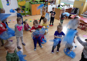 Dzieci tańczą z błękitną folią